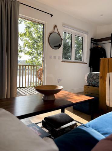 a living room with a coffee table and a balcony at Lakeside Lodge- 'Swallow' in Bishampton