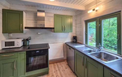 a kitchen with green cabinets and a sink at Nice Home In Aksdal With House Sea View in Aksdal