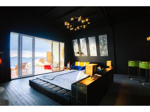a bedroom with a large bed and a large window at Oaga Art Resort Maldives - Greatest All Inclusive Plan with Free Speedboat Round-trip in North Male Atoll