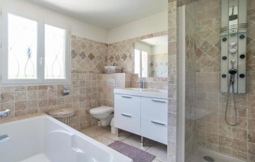 a bathroom with a tub and a toilet and a sink at Stunning Home In Peymeinade in Peymeinade