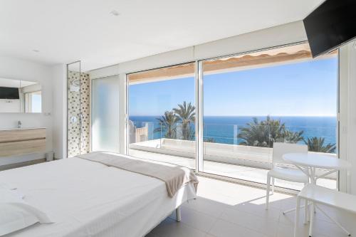 Un dormitorio blanco con vista al mar. en Villa Lizo, en El Campello