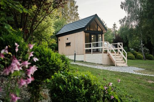 a small cabin with a black roof in a garden at Villa Biesisko Przysłup Cisna in Cisna