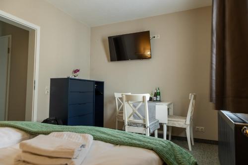 a bedroom with a bed and a desk and a tv at Spielzeughotel Sonneberg in Sonneberg
