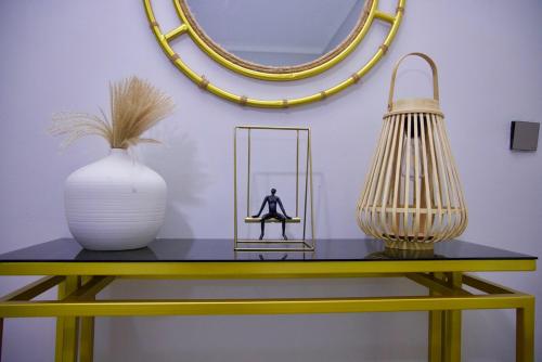 una mesa amarilla con un jarrón y un espejo en Luxury Comfort, en Kampala