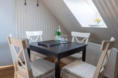 a black table with chairs and a bottle and drinks on it at Spielzeughotel Sonneberg in Sonneberg