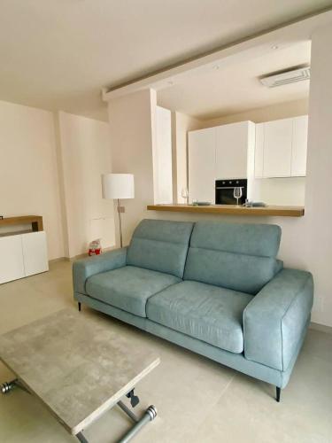 a living room with a blue couch and a table at Luxury Apartment with a View of Conegliano Castle in Conegliano