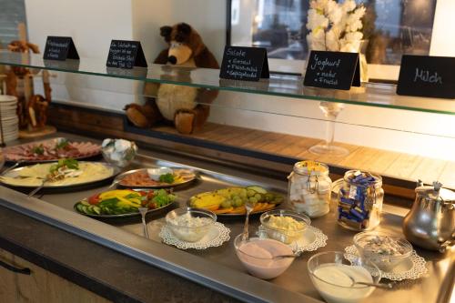a buffet line with plates of food in a restaurant at Spielzeughotel Sonneberg in Sonneberg
