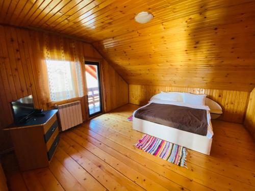 ein Schlafzimmer mit einem Bett und einem Fernseher in einem Zimmer in der Unterkunft Casa cristina in Gura Humorului