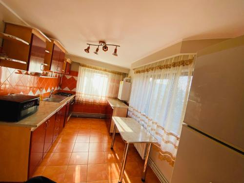 eine kleine Küche mit Tisch und Kühlschrank in der Unterkunft Casa cristina in Gura Humorului
