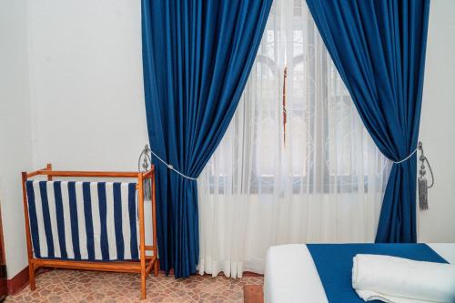 a bedroom with blue and white curtains and a bed at Coastal Heaven Villa in Trincomalee