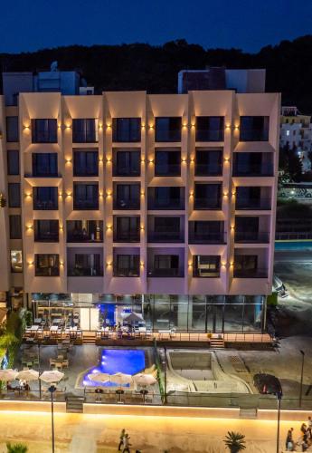 a hotel with a pool in front of a building at Aks Hotel in Durrës
