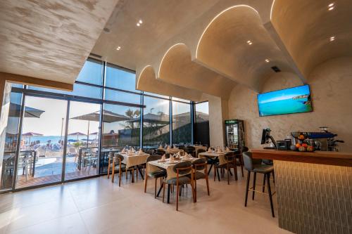 a restaurant with tables and chairs and a view of the ocean at Aks Hotel in Durrës