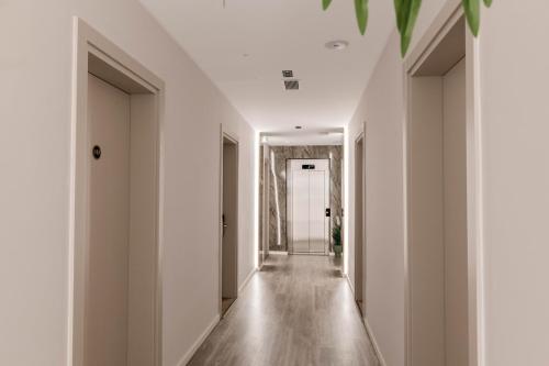 a hallway of a house with white walls and wooden floors at Aks Hotel in Durrës