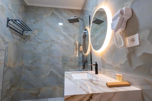 a bathroom with a sink and a phone on the wall at Aks Hotel in Durrës