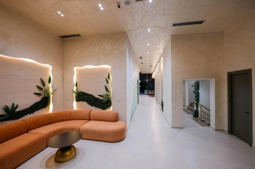 a living room with a couch and plants on the walls at Aks Hotel in Durrës