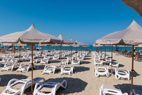 a bunch of chairs and umbrellas on a beach at Aks Hotel in Durrës