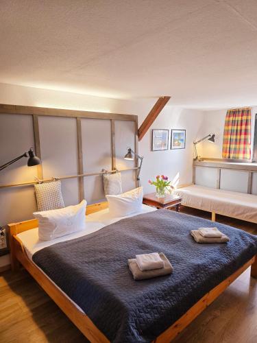 a bedroom with a large bed with two towels on it at Pension & Restaurant "Alte Schule" in Kluis