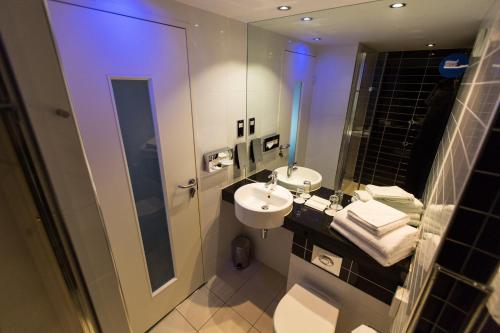 a bathroom with a sink and a toilet and a mirror at Holiday Inn Express London Stratford by IHG in London