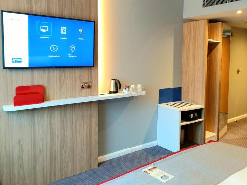 a room with a flat screen tv on a wall at Holiday Inn Express London Stratford by IHG in London
