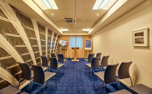 a conference room with chairs and a podium at Holiday Inn Express London Stratford by IHG in London
