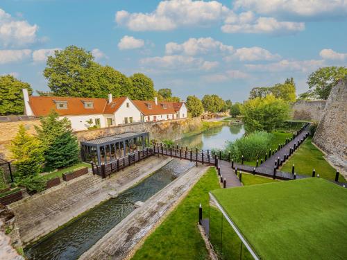 a view of a river with a building and a house at Platan Udvarhaz in Tata