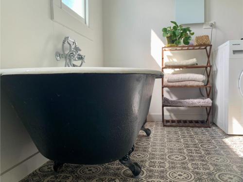 a bathroom with a large black bath tub at Havelock North Cottage on Organic Orchard in Havelock North