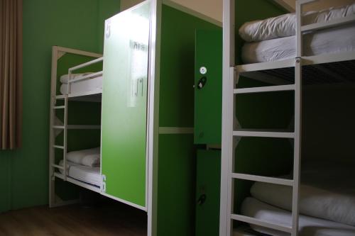 a room with green walls and bunk beds at Safestay Edinburgh Cowgate in Edinburgh