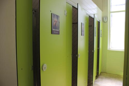 a hallway with green walls and mirrors and a window at Safestay Edinburgh Cowgate in Edinburgh