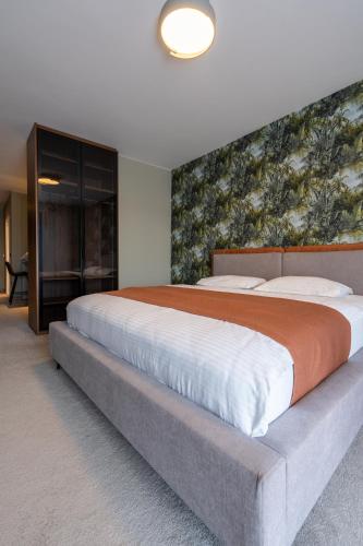 a large bed in a bedroom with a wall at Downtown Apartments in Pristina