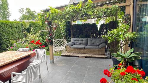 a patio with a couch on a swing at Two nice rooms in residential area with private bathroom in Almere