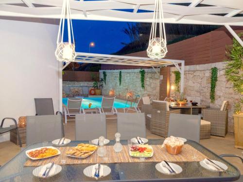 a dining room with a table with food and a pool at Villa Sky in Skaleta