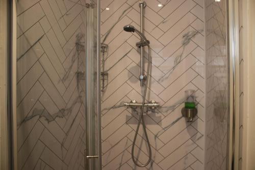 a shower in a bathroom with a white wall at Safestay Edinburgh Cowgate in Edinburgh