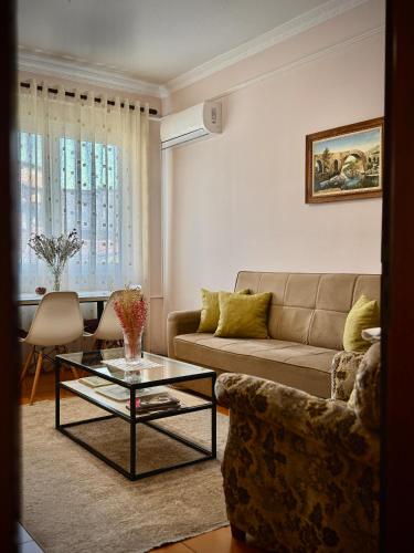 a living room with a couch and a table at All Seasons Apartments - Free Parking & City Center in Shkodër