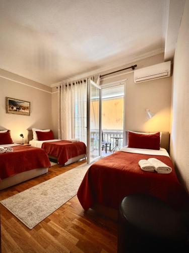 a hotel room with two beds and a balcony at All Seasons Apartments - Free Parking & City Center in Shkodër