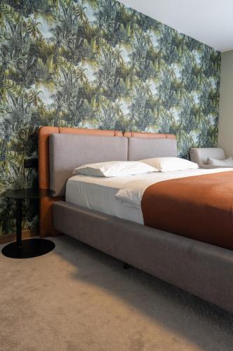 a bedroom with a bed and a wall with a floral wallpaper at Downtown Apartments in Pristina