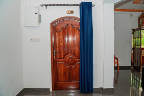 a wooden door in a room with a blue curtain at Coastal Heaven Villa in Trincomalee