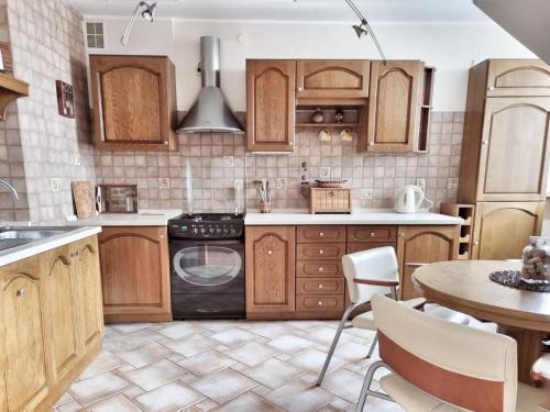 a kitchen with wooden cabinets and a table at Izabelin Apartment in Swarzędz