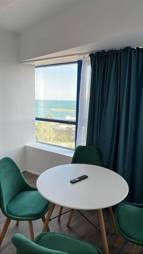 a room with a table and green chairs and a window at Olimp Sea View 607 in Olimp