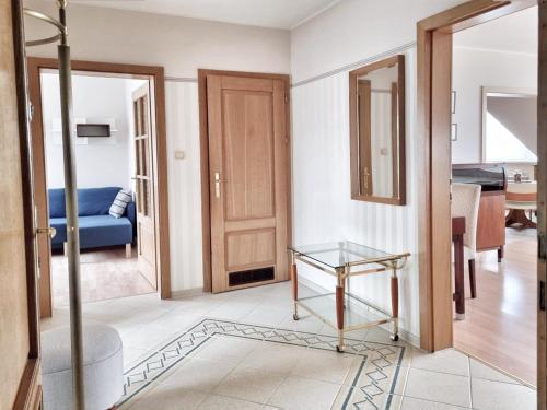 a room with a glass table and a blue couch at Izabelin Apartment in Swarzędz
