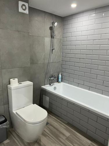 a bathroom with a white toilet and a bath tub at Olimp Sea View 607 in Olimp