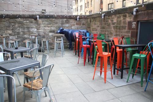 a room with tables and chairs and a cow statue at Safestay Edinburgh Cowgate in Edinburgh
