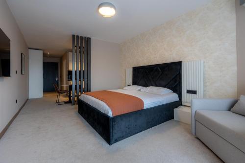 a bedroom with a bed and a couch at Downtown Apartments in Pristina