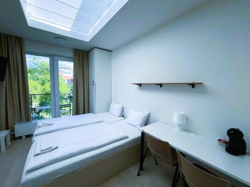 a room with two beds and a table and a window at Bella Apartments Brno in Brno