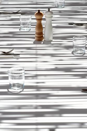 a table with glasses and two vases on it at ANEMI Folegandros in Karavostasi