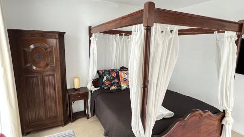 a bedroom with a wooden canopy bed with curtains at Two nice rooms in residential area with private bathroom in Almere