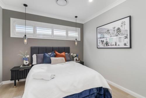 a bedroom with a large bed and a window at Luxury Hampton House with Heated pool in Narellan