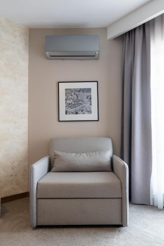 a chair sitting in a room next to a window at Downtown Apartments in Pristina