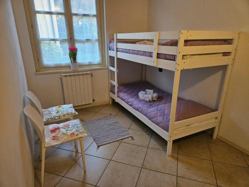 a small room with two bunk beds and a chair at Fiore di LOTO in Paratico