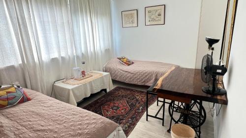 a room with two beds and a table and a piano at Two nice rooms in residential area with private bathroom in Almere