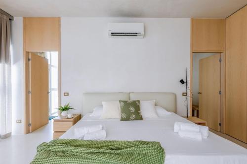 a bedroom with a white bed with a green blanket on it at Italian Experience- Suite Marè in Porto Recanati